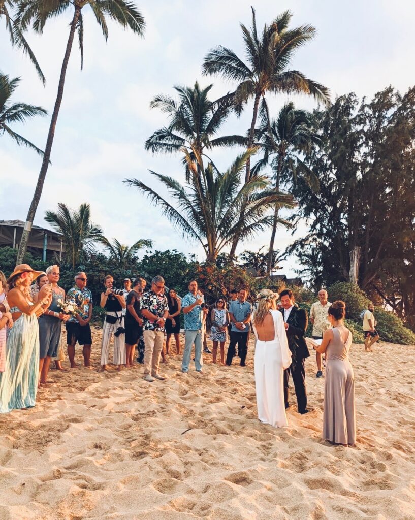 A couple and their wedding officiant on the beach in Oahu