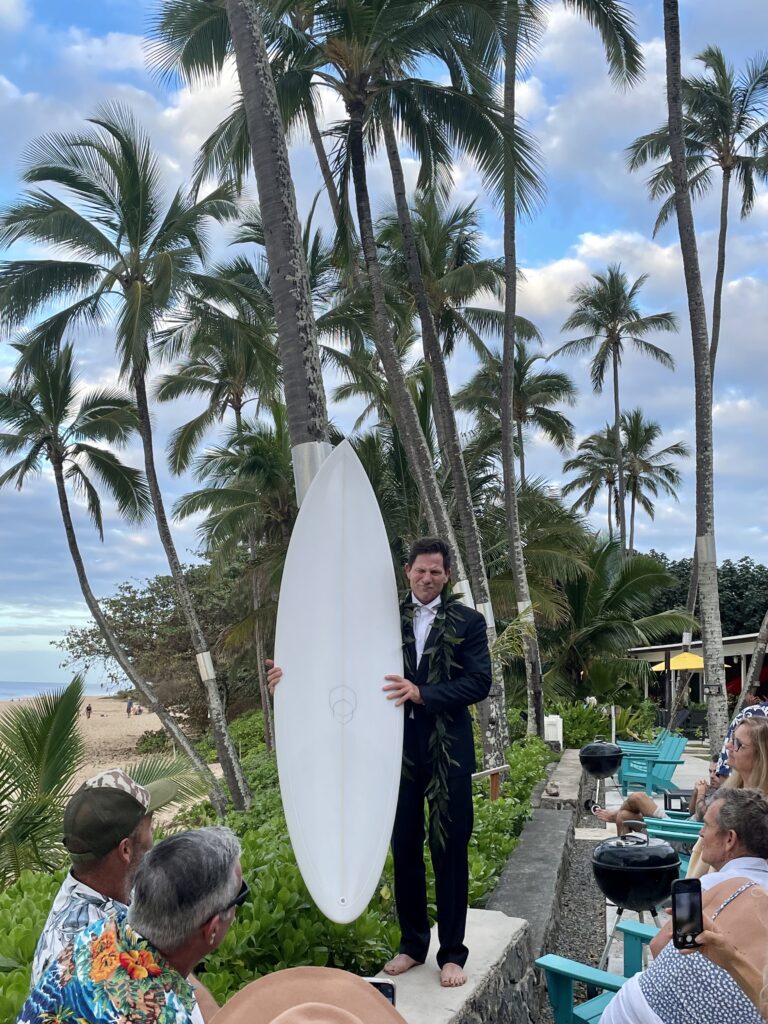 A man and his surfboard before having a simple wedding in hawaii
