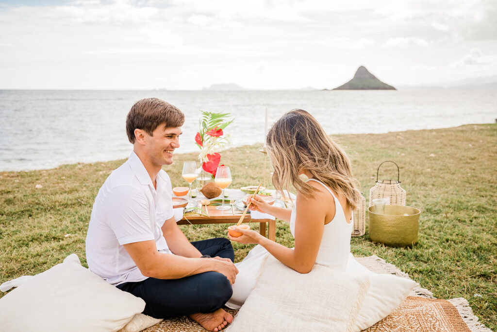 A couple enjoys a unique picnic with a view on their wedding day in Hawaii.