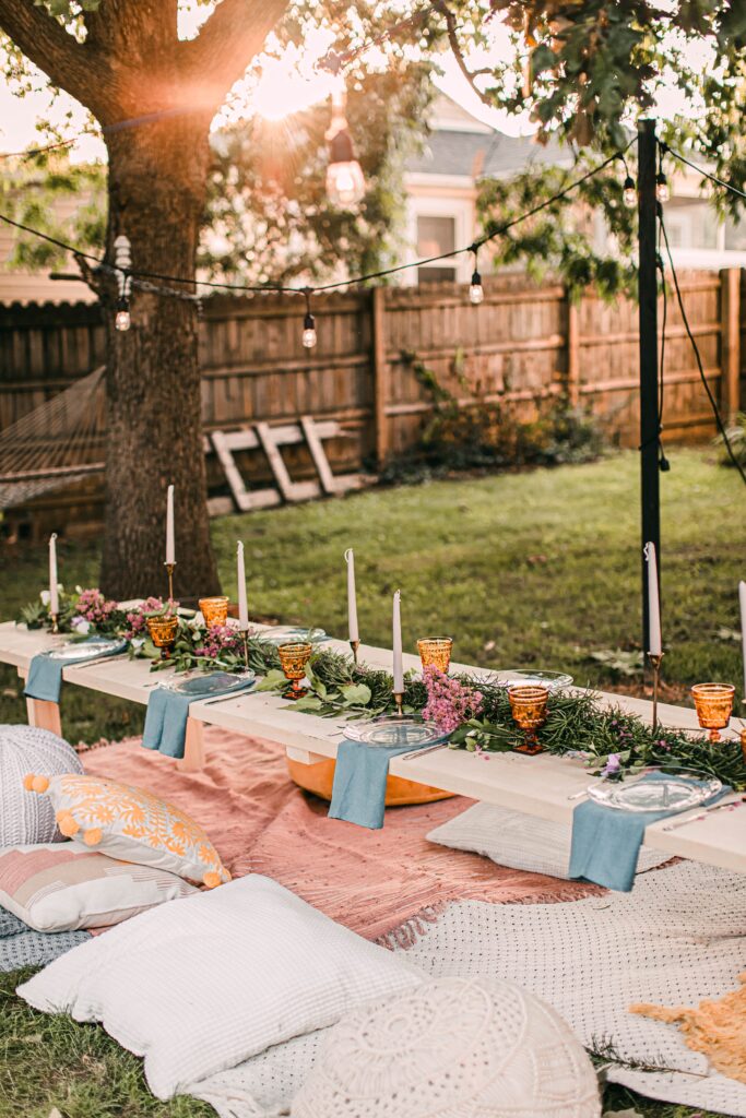 Wedding picnic set up with pillows, tables, and blankets on the ground