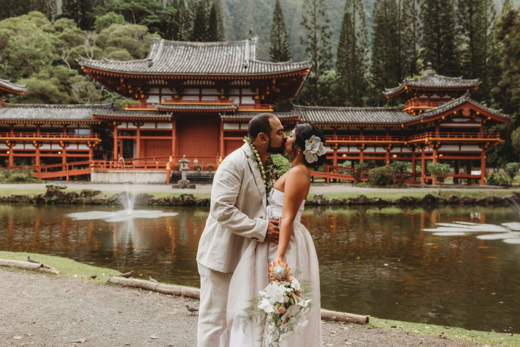 Couples kisses after Wedding in Hawaii at the Byodo temple in Kaneohe, Oahu. 