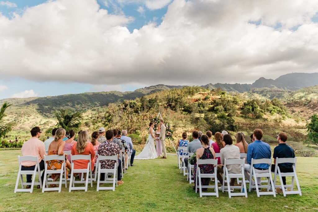 Couple celebrates their wedding day with about 30 guests at a lush and green mountain view venue in Oahu, Hawaii. 